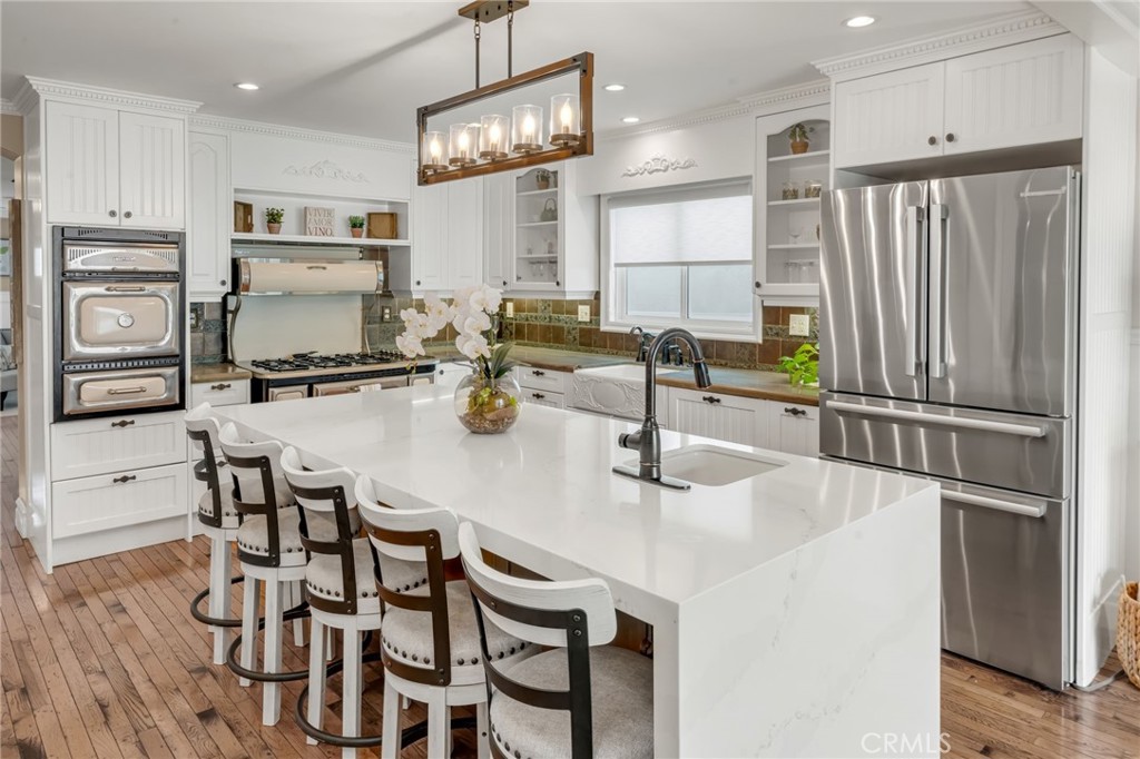 309 21st Street Huntington Beach, CA 92648 - Photo 13 of 38 a kitchen with refrigerator and chairs