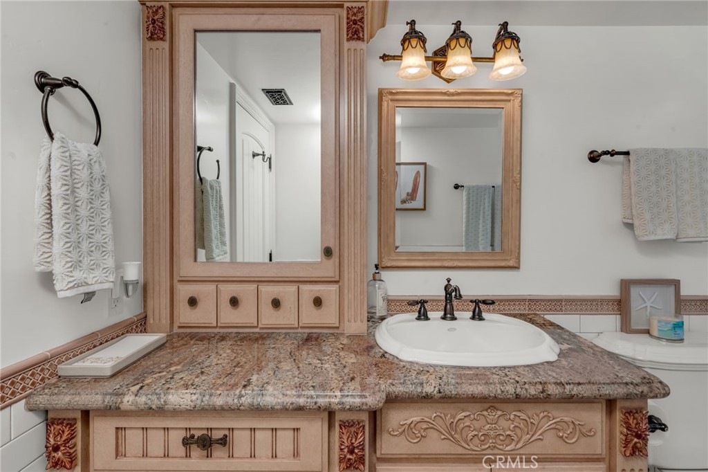 309 21st Street Huntington Beach, CA 92648 - Photo 18 of 38 a bathroom with a granite countertop sink and a mirror