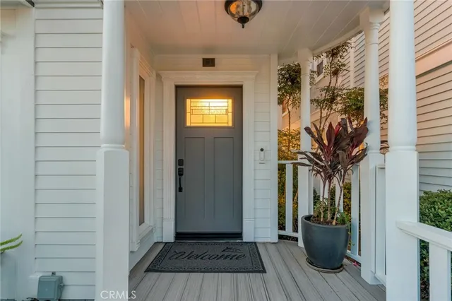a view of a patio with table and chairs potted plants and floor to ceiling window
