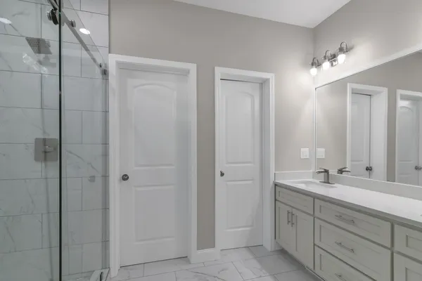 a bathroom with a double vanity sink a shower and a mirror