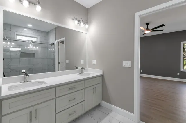 a bathroom with a double vanity sink and mirror with shower