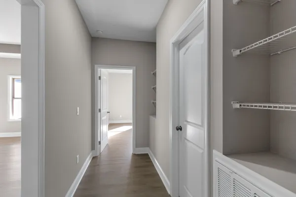 a view of a hallway with wooden floor and closet