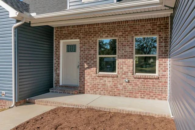 a brick house with a yard and large window