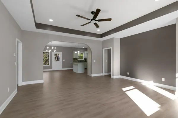 a view of a livingroom with a ceiling fan and wooden floor