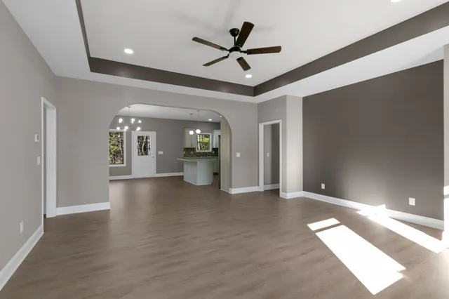a view of a livingroom with a ceiling fan and wooden floor