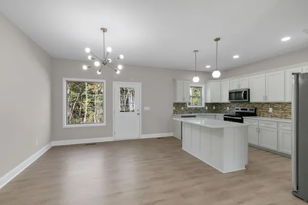 a kitchen with a white cabinets and window