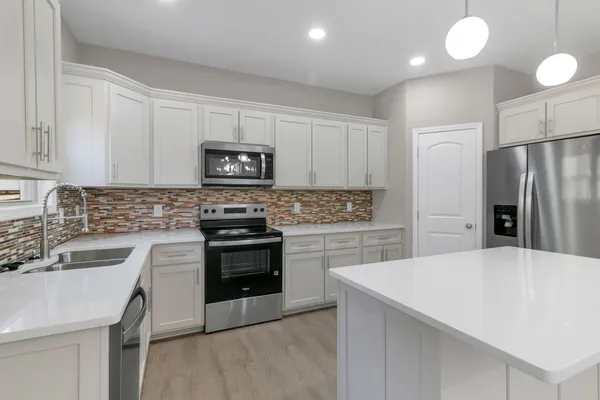 a kitchen with a sink a stove and refrigerator