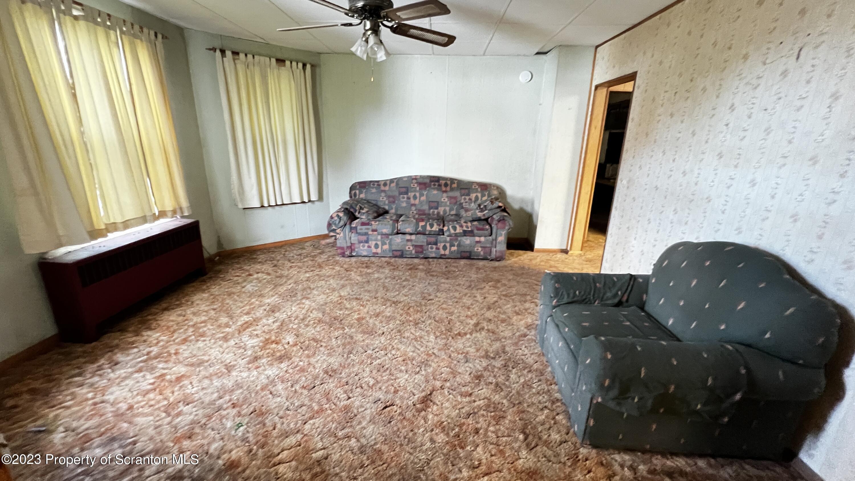 102 Wayne Street Carbondale, PA 18407 - Photo 11 of 21 a living room with a couch and a floor to ceiling window