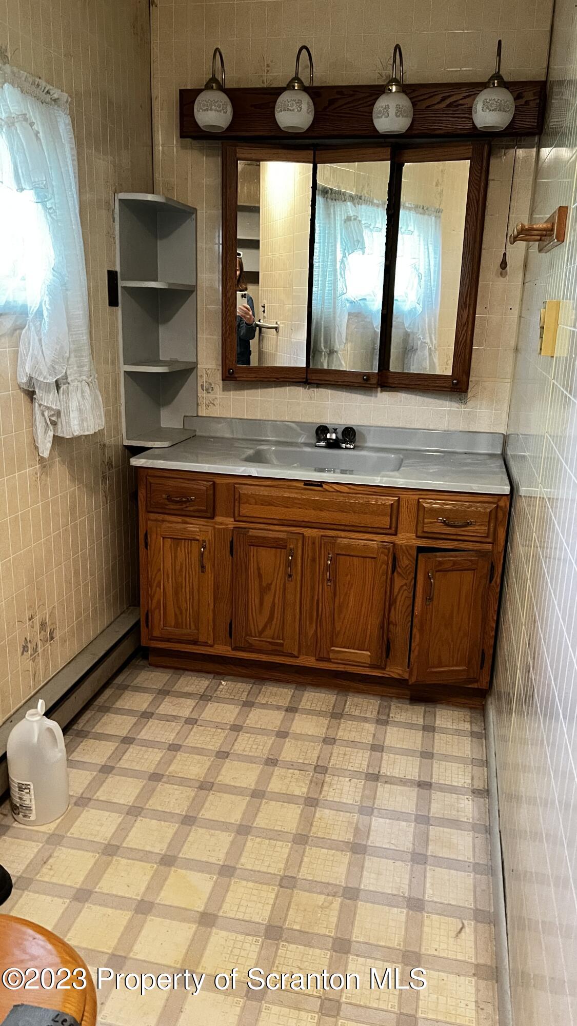 102 Wayne Street Carbondale, PA 18407 - Photo 20 of 21 a bathroom with a sink a mirror and a bathtub