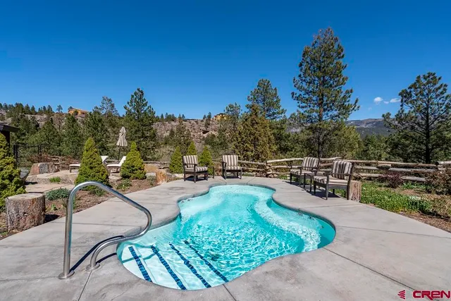 a view of a swimming pool with a patio and a yard
