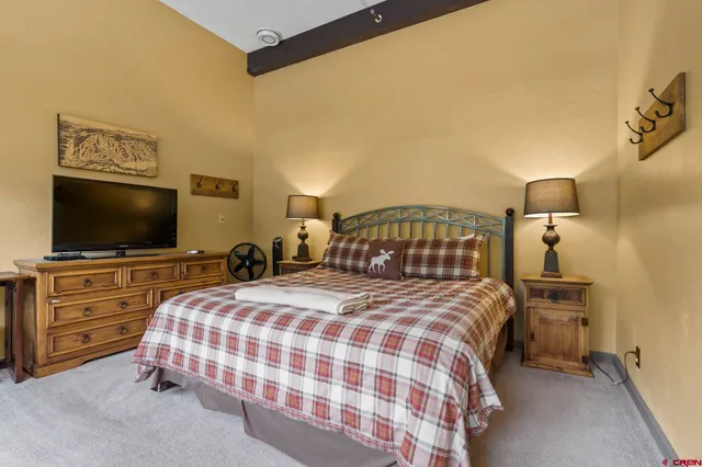 a bedroom with a bed and a flat screen tv