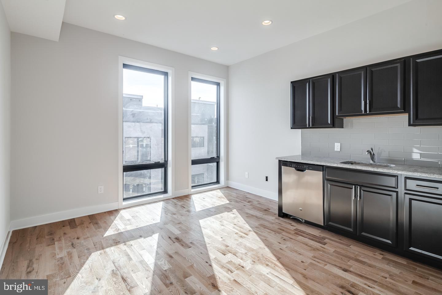 a view of a kitchen with stainless steel appliances granite countertop a sink and cabinets