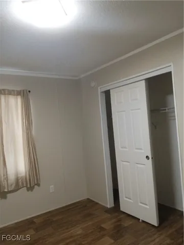 an empty room with wooden floor and closet
