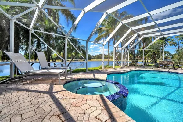 a view of a swimming pool with a patio and a yard