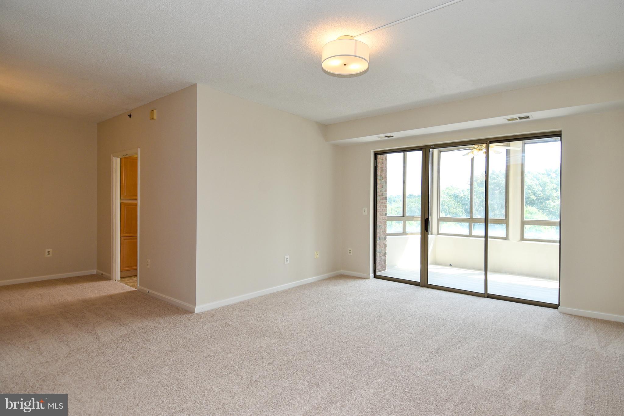3200 North Leisure World Boulevard, Unit 407 Silver Spring, MD 20906 - Photo 9 of 38 Living room has enclosed balcony access