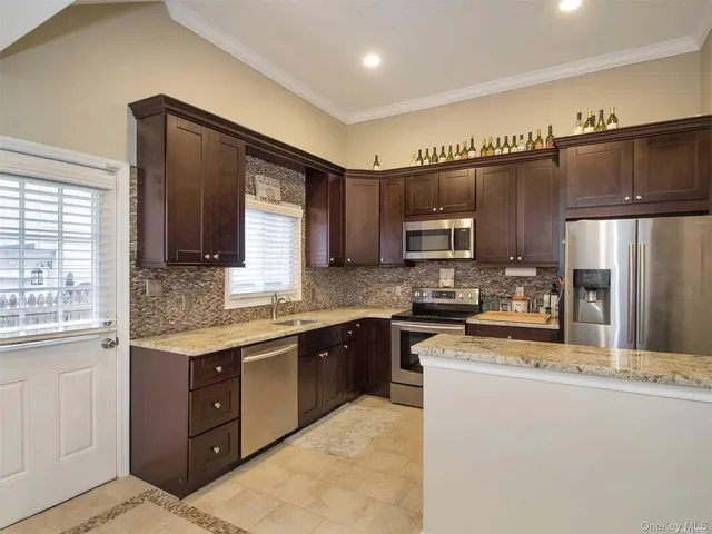 a kitchen with stainless steel appliances granite countertop a refrigerator a sink dishwasher a stove top oven and a refrigerator