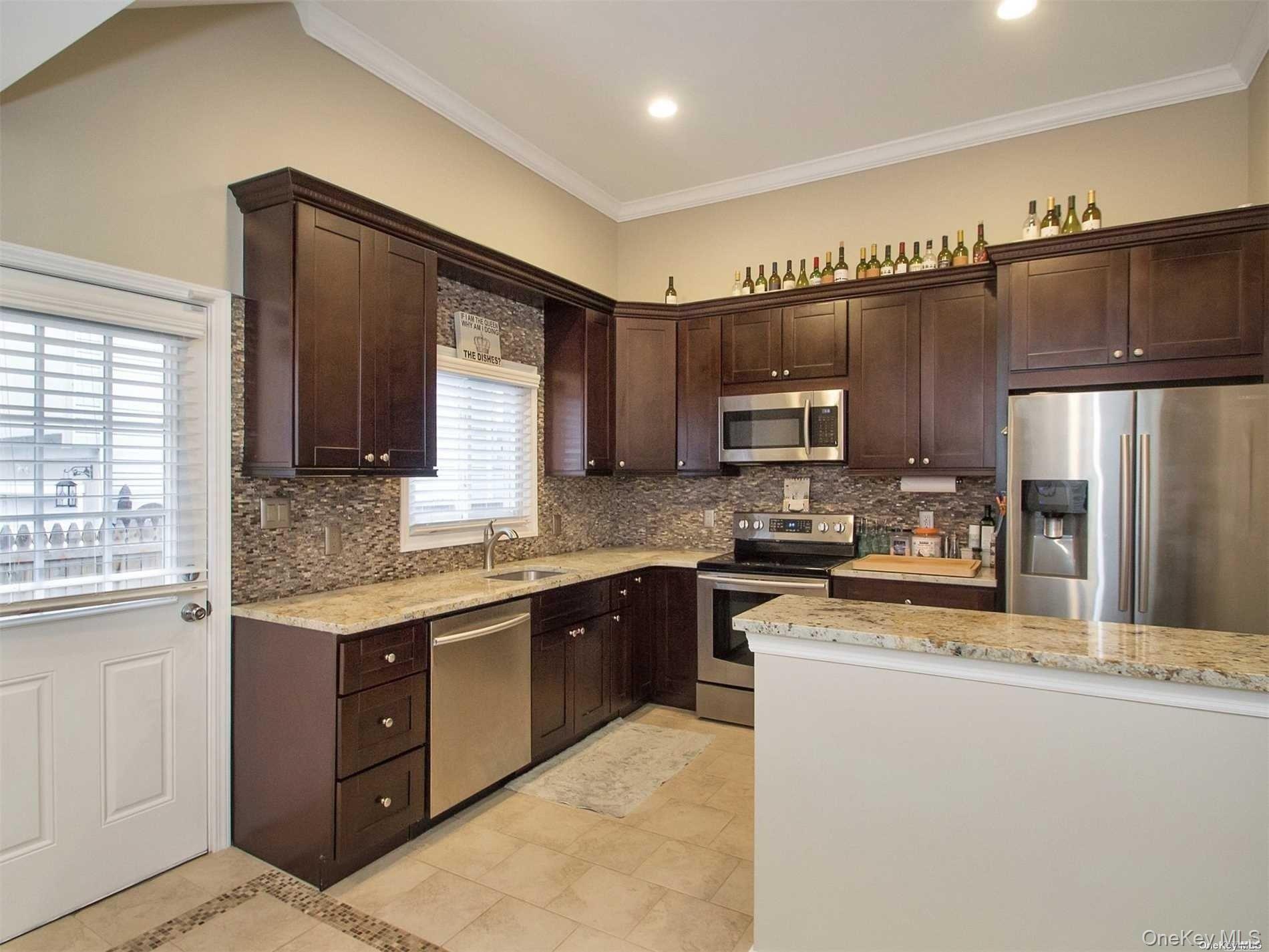 11 Pratt Street West Babylon, NY 11704 - Photo 2 of 15 a kitchen with stainless steel appliances granite countertop a refrigerator a sink dishwasher a stove top oven and a refrigerator