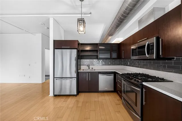 a kitchen with stainless steel appliances kitchen island granite countertop a refrigerator and a stove