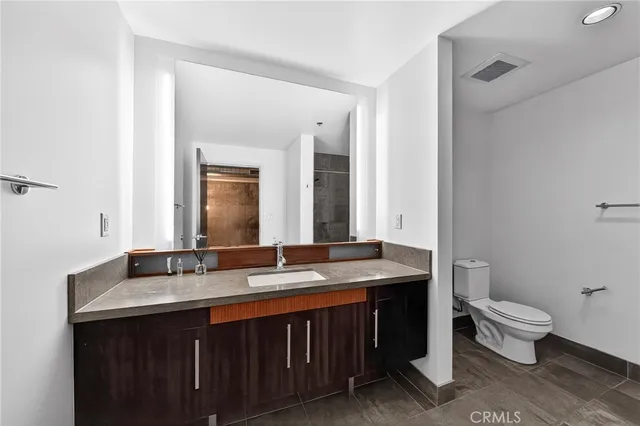 a bathroom with a double vanity sink toilet and mirror