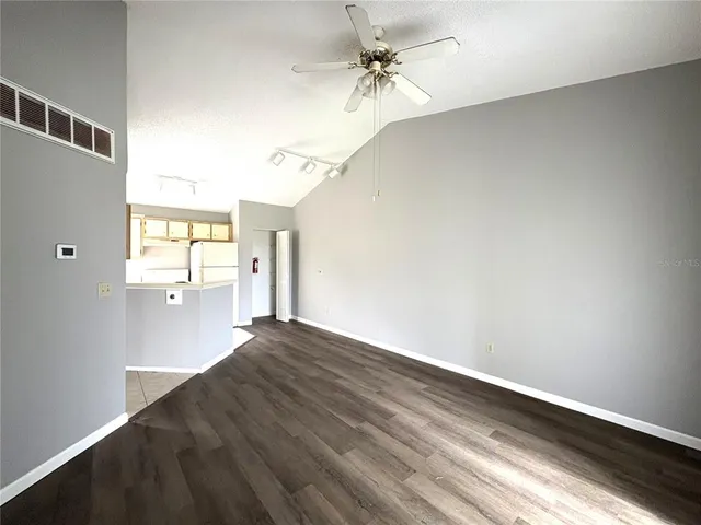 a view of a big room with wooden floor and windows