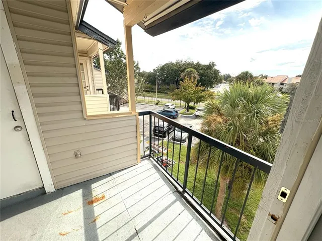 a view of a balcony with wooden floor and fence