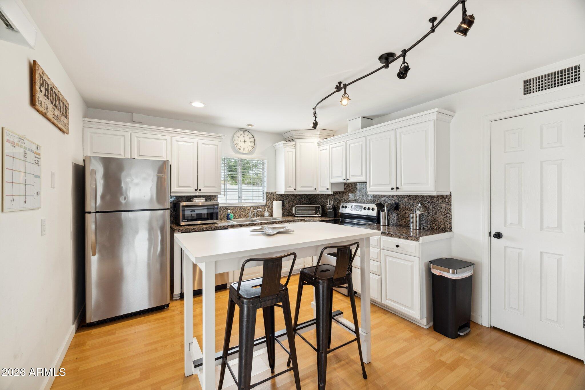 4723 South Country Club Way Tempe, AZ 85282 - Photo 10 of 46 a kitchen with stainless steel appliances granite countertop a refrigerator a sink a stove a dining table and chairs