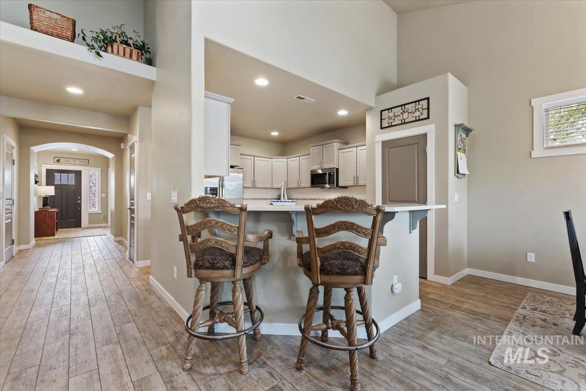 1011 West Riodosa Drive Meridian, ID 83642 - Photo 16 of 38 Kitchen with arched walkways, white cabinetry, a breakfast bar, light wood-type flooring, and recessed lighting