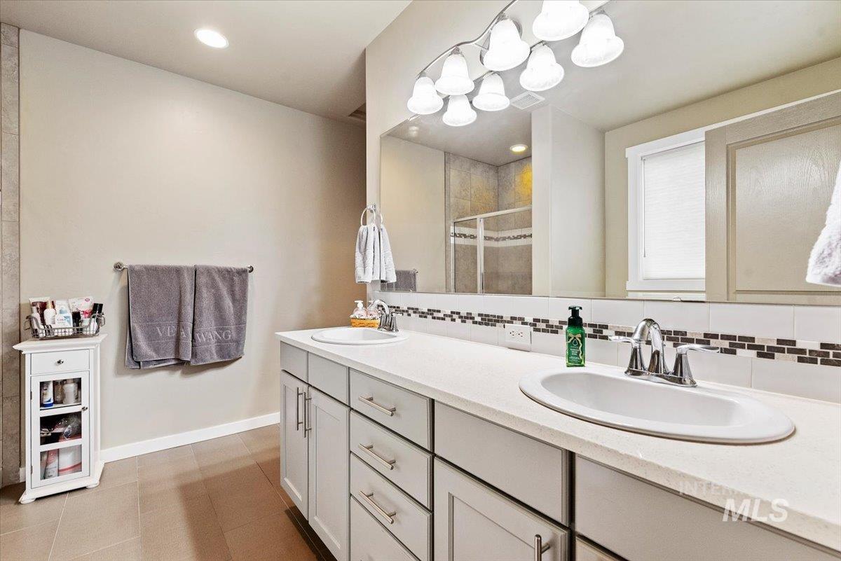 1011 West Riodosa Drive Meridian, ID 83642 - Photo 23 of 38 Bathroom with double vanity, backsplash, recessed lighting, and a stall shower