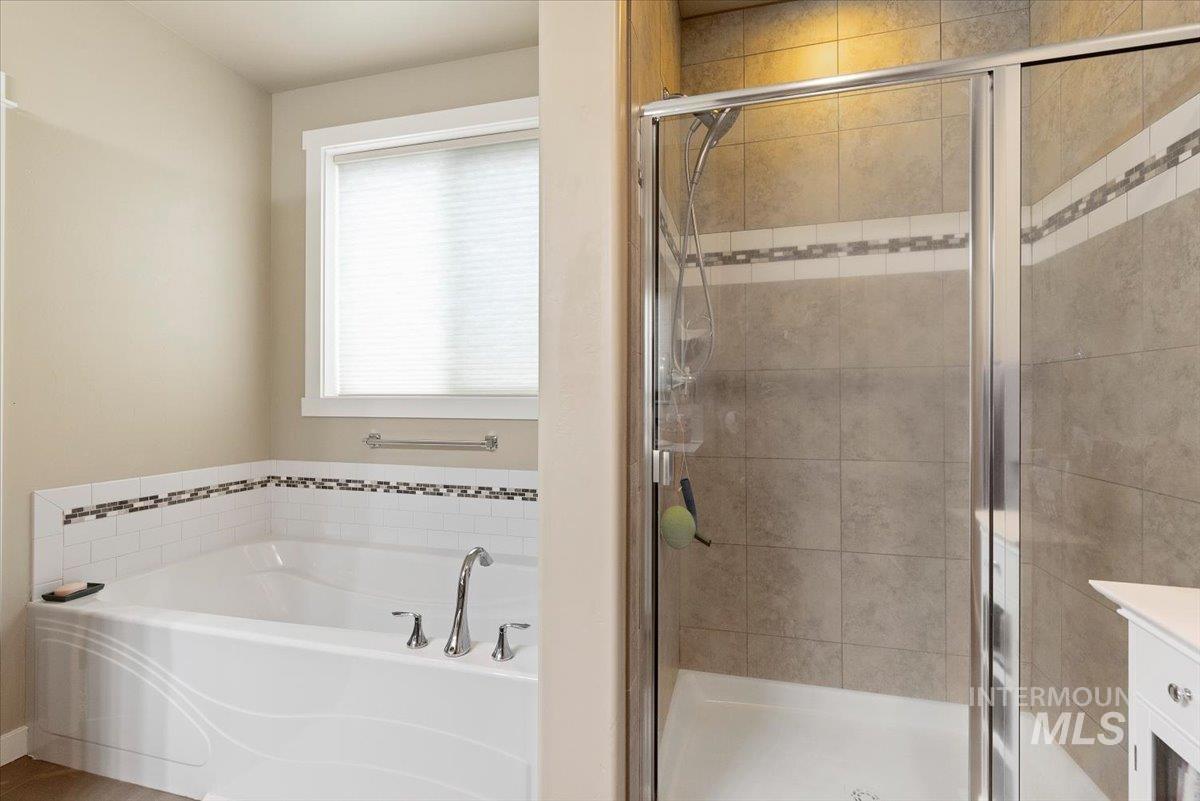 1011 West Riodosa Drive Meridian, ID 83642 - Photo 24 of 38 Full bathroom featuring vanity, a stall shower, and a garden tub