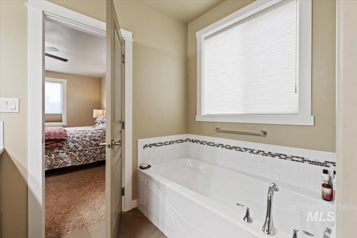 1011 West Riodosa Drive Meridian, ID 83642 - Photo 30 of 38 Bathroom featuring light carpet, ensuite bath, a bath, and light tile patterned floors