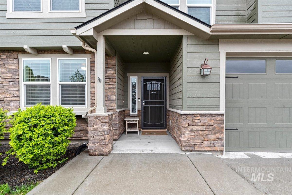 1011 West Riodosa Drive Meridian, ID 83642 - Photo 5 of 38 Property entrance featuring stone siding, covered porch, and an attached garage