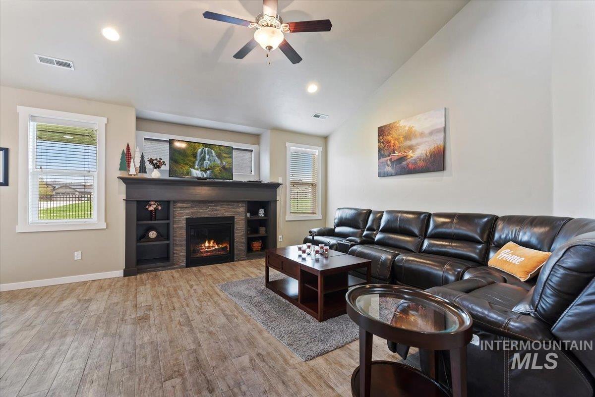 1011 West Riodosa Drive Meridian, ID 83642 - Photo 10 of 38 Living room featuring light wood-style floors, ceiling fan, recessed lighting, lofted ceiling, and a fireplace