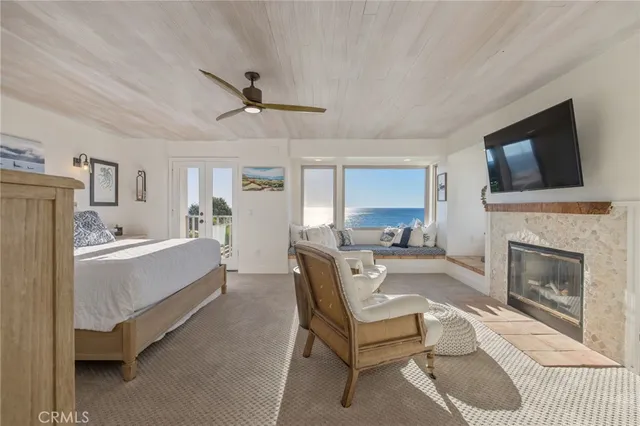 a living room with furniture a flat screen tv and a floor to ceiling window