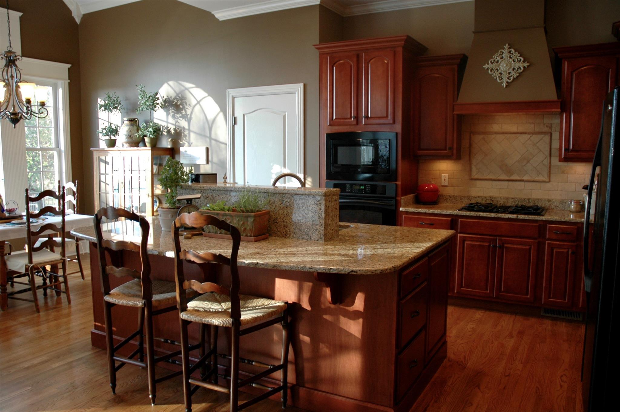 1604 Fair House Road Spring Hill, TN 37174 - Photo 6 of 18 a kitchen with granite countertop a table chairs stove and cabinets