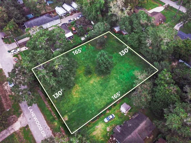 a green field with lots of trees in the background