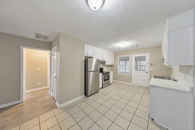 a kitchen with a refrigerator sink and cabinets