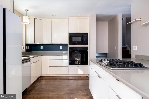 a kitchen with granite countertop a stove a sink and a refrigerator