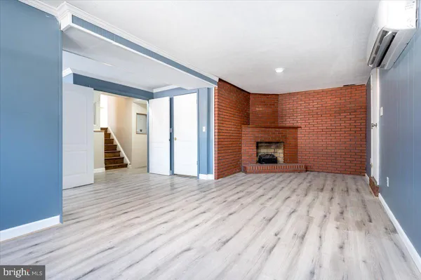 a view of empty room with wooden floor and fireplace