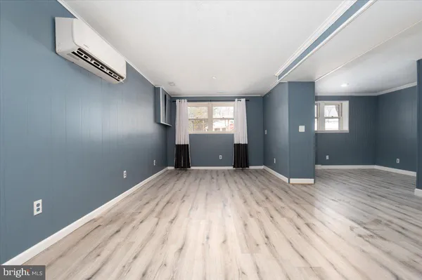a view of empty room with wooden floor and window