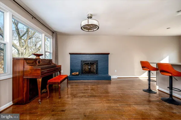 a living room with furniture a piano and a fireplace