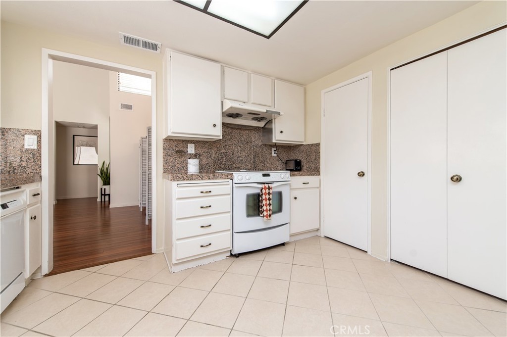 9 Morena, Unit 28 Irvine, CA 92612 - Photo 11 of 27 a kitchen with white cabinets and white appliances