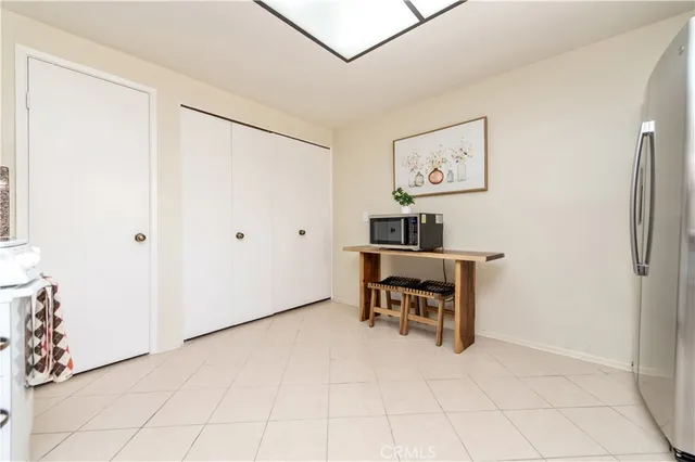 a view of a workspace with furniture and a refrigerator