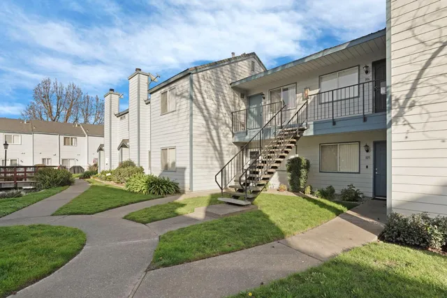 a front view of a house with a yard and outdoor seating