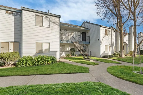 a front view of a house with a yard and green space