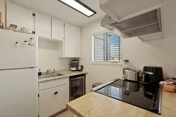 a kitchen with a refrigerator and a stove top oven