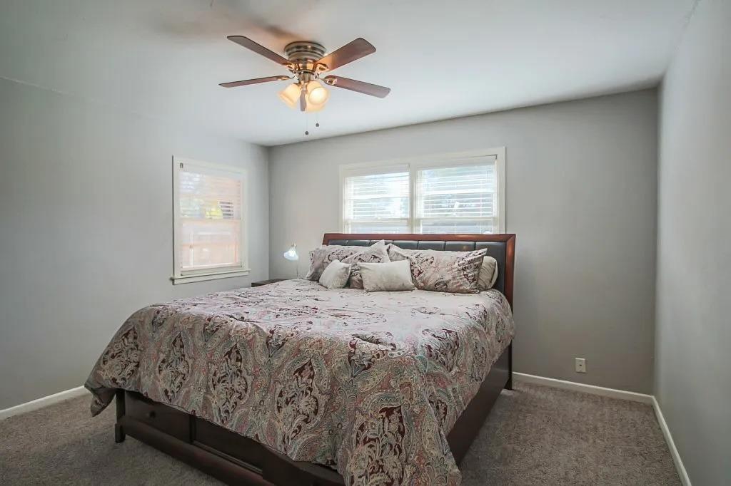 3011 37th Street Lubbock, TX 79413 - Photo 6 of 11 a bedroom with a bed and a chandelier