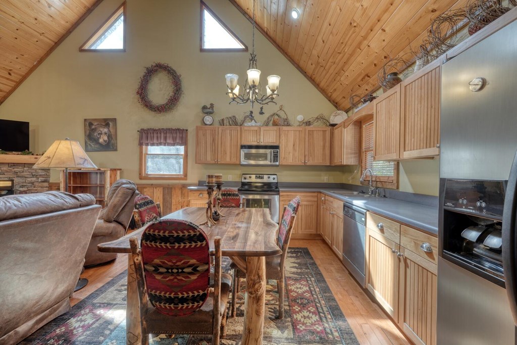4852 Hf Lyons Road Hiawassee, GA 30546 - Photo 18 of 48 a kitchen with stainless steel appliances granite countertop a stove top oven a sink dishwasher a dining table and chairs with wooden floor