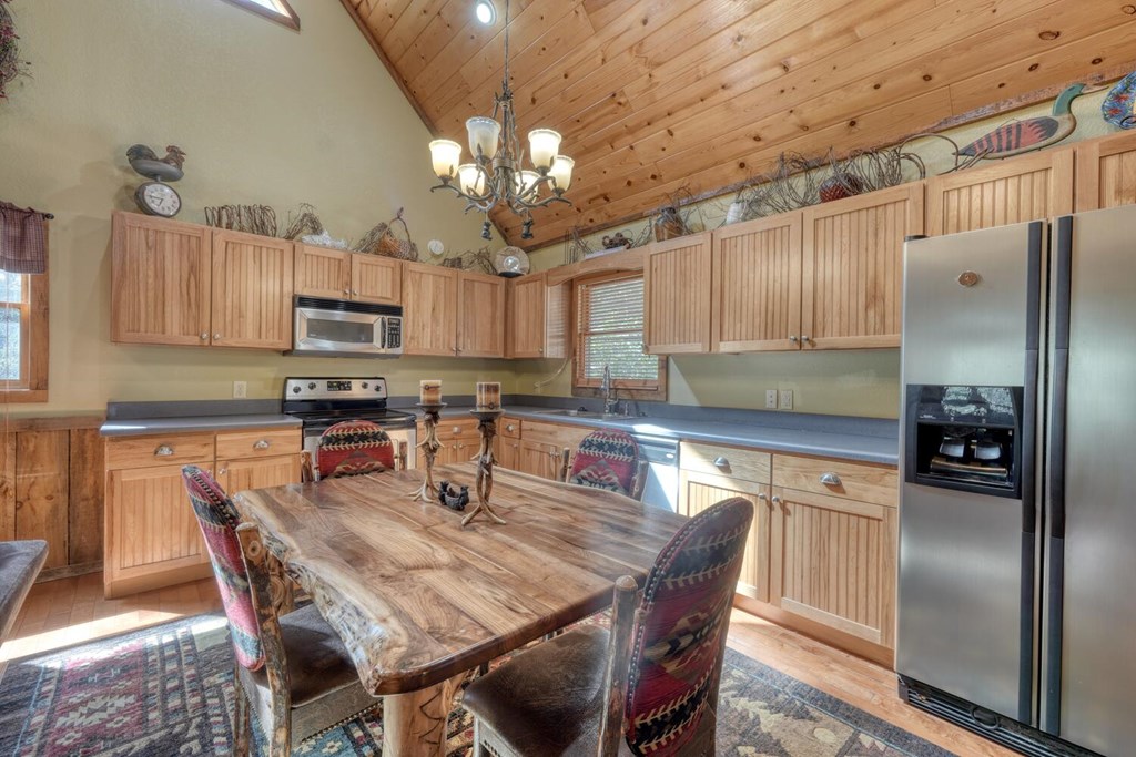 4852 Hf Lyons Road Hiawassee, GA 30546 - Photo 19 of 48 a kitchen with kitchen island granite countertop a refrigerator a stove a sink dishwasher with a dining table and chairs