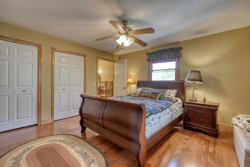 4852 Hf Lyons Road Hiawassee, GA 30546 - Photo 20 of 48 a spacious bedroom with a bed and a chandelier