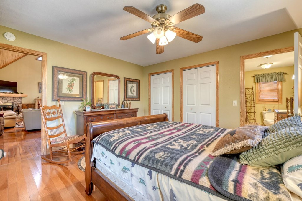 4852 Hf Lyons Road Hiawassee, GA 30546 - Photo 21 of 48 a bedroom with a large bed and a chandelier